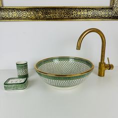 a sink and faucet in a bathroom next to a framed painting on the wall