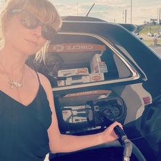 a woman filling up her car with gas