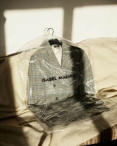 a suit jacket is wrapped in plastic on a bed