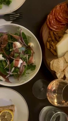 a table topped with plates of food and wine glasses