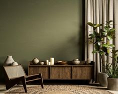 a living room with green walls and a rug on the floor next to a chair