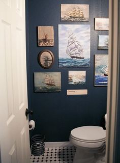 a bathroom with blue walls and pictures on the wall