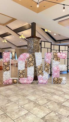 the word love spelled out in front of a fireplace with pink and white balloons on it