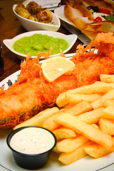 fish and fries on a plate with dipping sauces next to some condiments