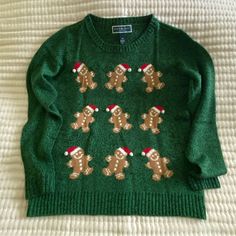 a green sweater with gingerbreads on it