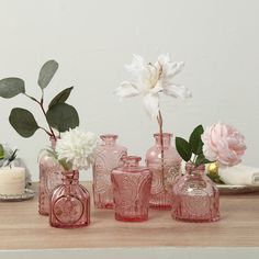 pink glass vases with white flowers and greenery