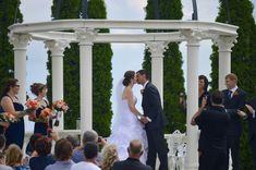 a bride and groom are standing under an arch at the end of their wedding ceremony