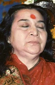 a woman with her eyes closed wearing a red nose ring