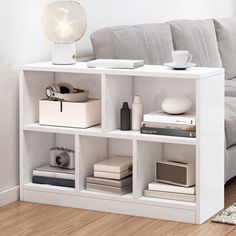 a white shelf filled with books and other items on top of eachother in front of a white background