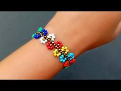 a woman's arm with a colorful bracelet on her left wrist and multi - colored beads on it