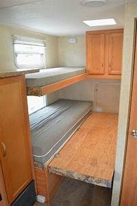 the inside of an rv with bunk beds and cupboards in it's center