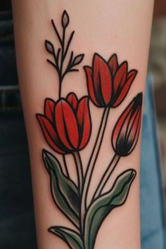 a woman's arm with red flowers and leaves on the left side of her body