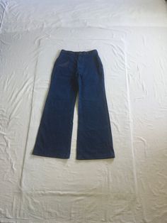 "vintage 1970s jeans Wrangler dark wash denim cotton feel (tag too faded to read) bell bottom leg high waist SCOVILL zipper black bar  1 front left small pocket 2 back pockets 4 wide width (2 1/2\") but skinny height (1 1/2\") belt loops multi-color stitching on pockets/trim good vintage condition, light wear have been hemmed, looks to have at least 1 1/4\" that could be taken out size tag faded out measures, lying flat, waist-15 1/2\" to 16\" w/a tug rise-13 1/2\" hip-22\" inseam-32 1/2\" hem-12\" outseam-44 1/2\"" Dark Wash Full Length Cotton Flares, Full-length Dark Wash Cotton Flares, Full Length Dark Wash Cotton Flares, Retro Fitted Dark Wash Flares, Retro High Rise Dark Wash Flares, Full Length Medium Wash Cotton Flares, Vintage Fitted Denim Blue Flare Jeans, Fitted Vintage Denim Blue Flare Jeans, Vintage Fitted Flare Jeans In Denim Blue