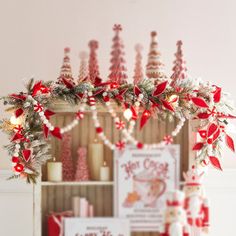 a shelf with christmas decorations and candles on it