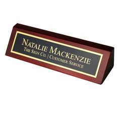 a black and gold plaque with the name natalie mackenzie on it's side