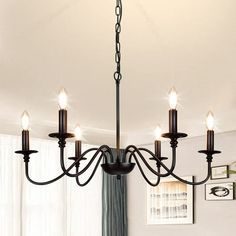 a chandelier hanging from the ceiling in a room with white walls and curtains