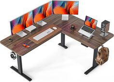 a computer desk with two monitors and a laptop on it