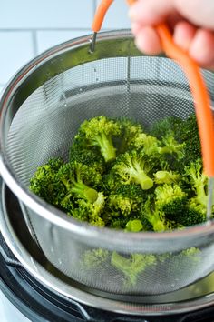 a person is grating broccoli in a strainer