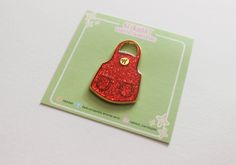 a red glittered purse shaped keychain on top of a card