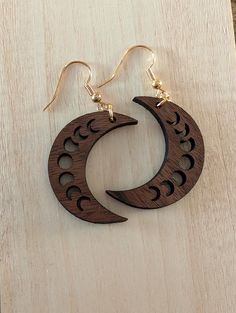 Add a touch of celestial charm to your outfit with these laser-cut walnut wood moon earrings! Handcrafted with precision and attention to detail, these earrings showcase a beautiful crescent moon design that is sure to make a statement. The warm tones of the walnut wood complement any style, making these earrings a versatile accessory for any occasion. Lightweight and comfortable to wear, these moon earrings are perfect for adding a touch of nature-inspired elegance to your look. Upgrade your jewelry collection with these unique and stylish earrings today! Crescent Moon Design, Wood Moon, Laser Cut Wood Earrings, Stylish Earring, Moon Design, Laser Cut Wood, Moon Earrings, Wood Earrings, Walnut Wood