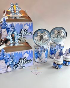 an assortment of blue and white items on display with snowflakes in the background