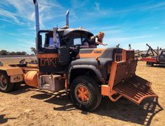 an orange and black truck with two people in it