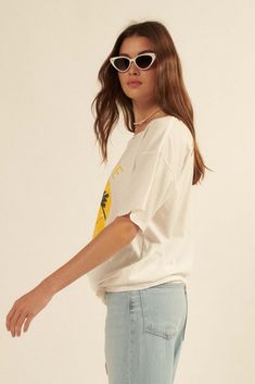 Distressed, garment washed graphic t-shirt. Vintage-style hammock and palm trees smiley face graphic print with "Love Life" text. Torn and distressed detailing at neckline, cuffs, and hem. Round neckline. Short sleeves. Drop shoulder. Oversized fit. 100% Cotton. Imported top designed and printed in LA. Model wears size S. Casual Summer T-shirt With Frayed Hem, Relaxed Summer Tops With Frayed Hem, Trendy Frayed Hem Summer T-shirt, Casual Frayed Hem T-shirt For Summer, Summer Crew Neck T-shirt With Frayed Hem, Distressed Relaxed Summer Tops, Relaxed Distressed Summer Tops, Relaxed Distressed Tops For Summer, Oversized Summer T-shirt With Frayed Hem