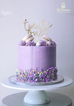 there is a cake with purple frosting and sprinkles on the top