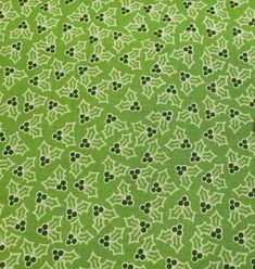 a green and white fabric with small black dots on the top, in an ornate pattern