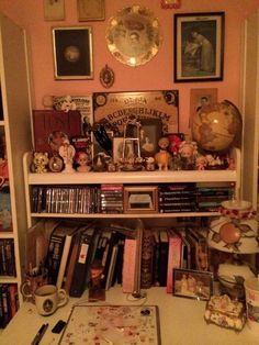 a room filled with lots of books and pictures on the wall next to a desk