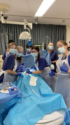 several people in scrubs and masks are preparing to perform surgery on an operating table