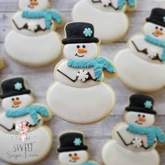 frosted snowman cookies with hats and scarfs are arranged next to each other