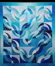 a blue and white quilt with waves on it