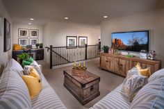 a living room filled with furniture and a flat screen tv mounted to the side of a wall