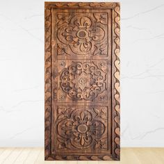 an intricately carved wooden door in front of a white wall