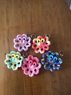 four crocheted keychains with eyeballs on them sitting on a table