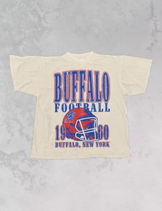 Show the love for your favorite team on game day in this Buffalo, New York Football oversized crewneck that is inspired by vintage 90s N F L sweatshirts! - Features Buffalo across the top with a football helmet and 1960 with Buffalo, New York underneath all in a blue and red ink - Sublimation transfer that is heat pressed onto each tshirt Tshirt is a super soft vintage wash that gets softer after each wash - Oversized fit - Sizing translation: XS/S = L , S/M = XL , L/XL = 2XL , 2XL/3XL = 3XL , 4 Buffalo Football, New York Football, Buffalo New York, Oversized Crewneck, Football Helmet, A Football, Formal Business, Red Ink, Outfits With Hats