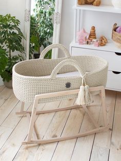 a baby's rocking chair in the middle of a room with white walls and wooden floors