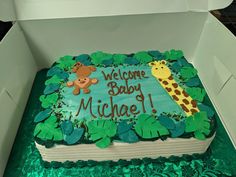 a baby shower cake with a giraffe and monkey on it in a box