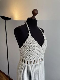 a mannequin wearing a white crochet halter top and matching skirt