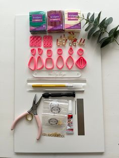 some crafting supplies are laid out on a white board with scissors and other items