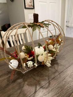 a white pumpkin decorated with flowers sitting on top of a wooden table