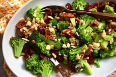 broccoli salad with nuts and cranberries in a white bowl