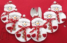 a group of snowmen sitting next to each other on top of a red table