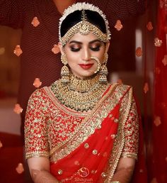 a woman in a red and gold bridal outfit