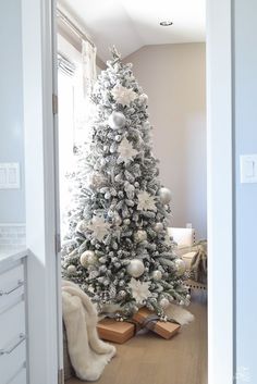 a white christmas tree in the corner of a room