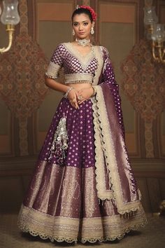 Dark purple attached cancan lehenga with floral, paisley banarasi woven motifs and gota, dori, badla embroidered border. Paired with neckline embroidered padded blouse and scallop embroidered dupatta. - Aza Fashions Anita Dongre Banarasi Lehenga, Purple Banarasi Lehenga, Banarasi Lehenga Sabyasachi, Lehenga With Border, Banarasi Bridal Lehenga, Banaras Lehenga, Sabyasachi Dresses, Bandhani Lehenga, Sabyasachi Lehenga Bridal