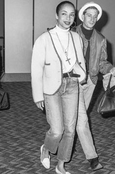 two people standing next to each other in an airport