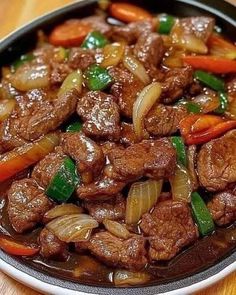 beef and vegetables in a bowl on a wooden table