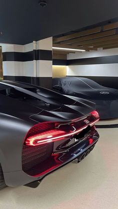 two sports cars parked in a garage next to each other